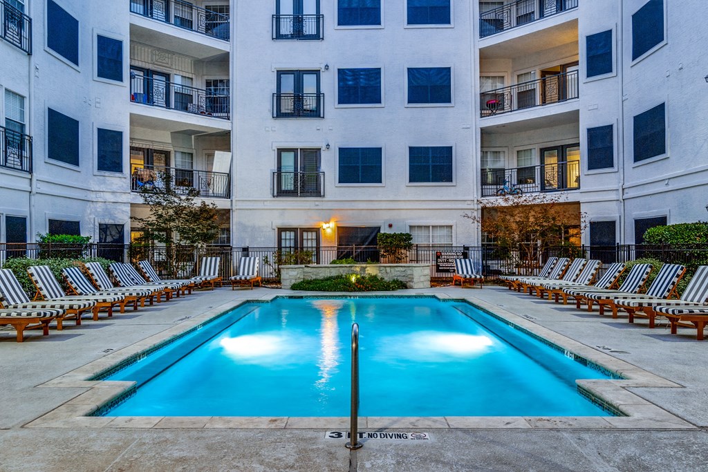an apartment swimming pool in front of an apartment building