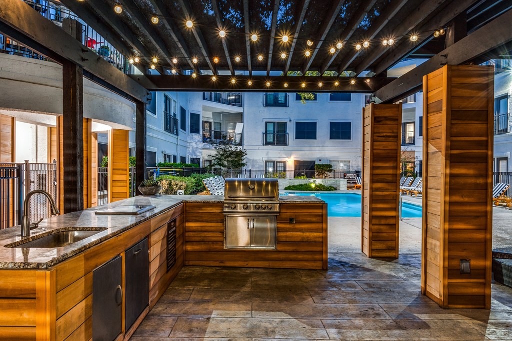 a kitchen with a sink and a stove in a backyard with a pool