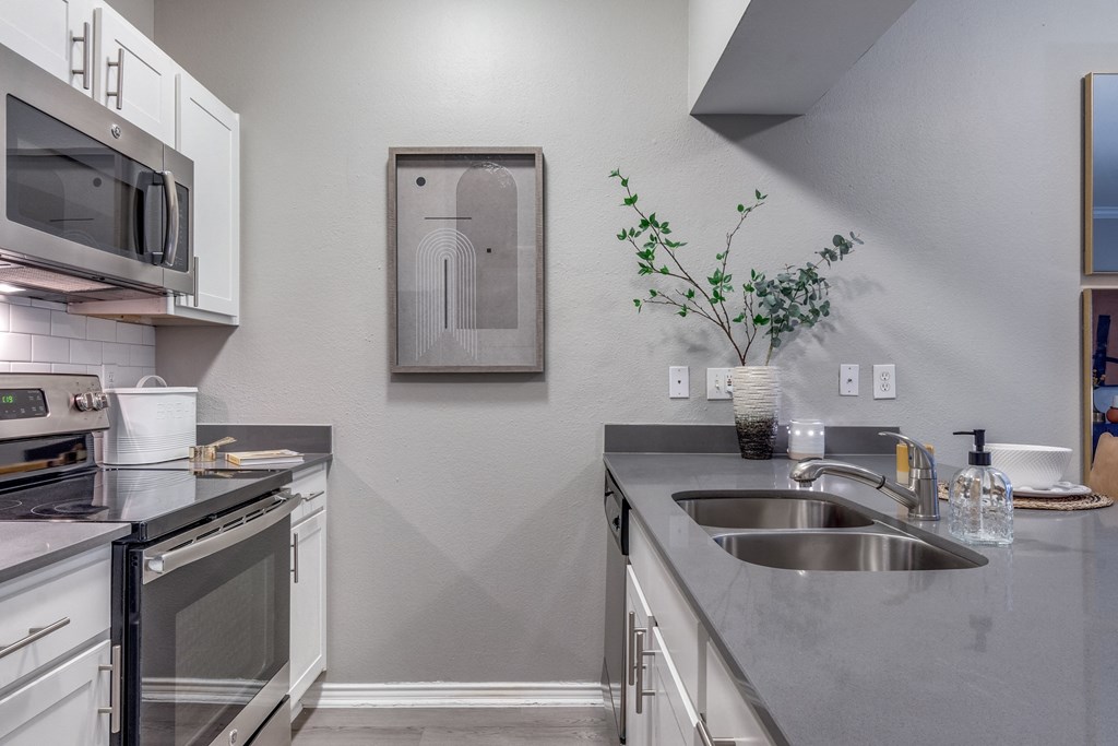 an empty kitchen with stainless steel appliances and a sink