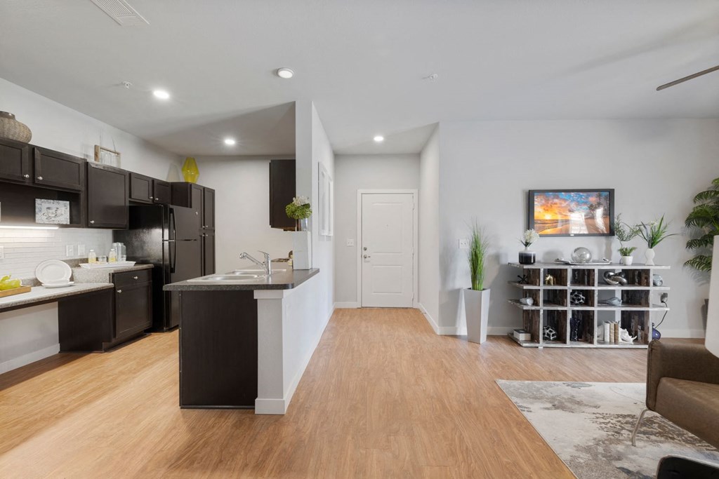 A modern kitchen with dark brown cabinets and a white countertop.