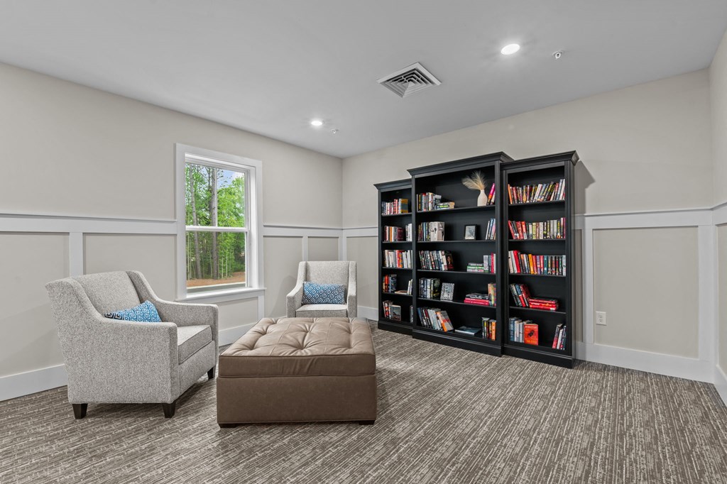 a living room with a couch and chairs and a book shelf