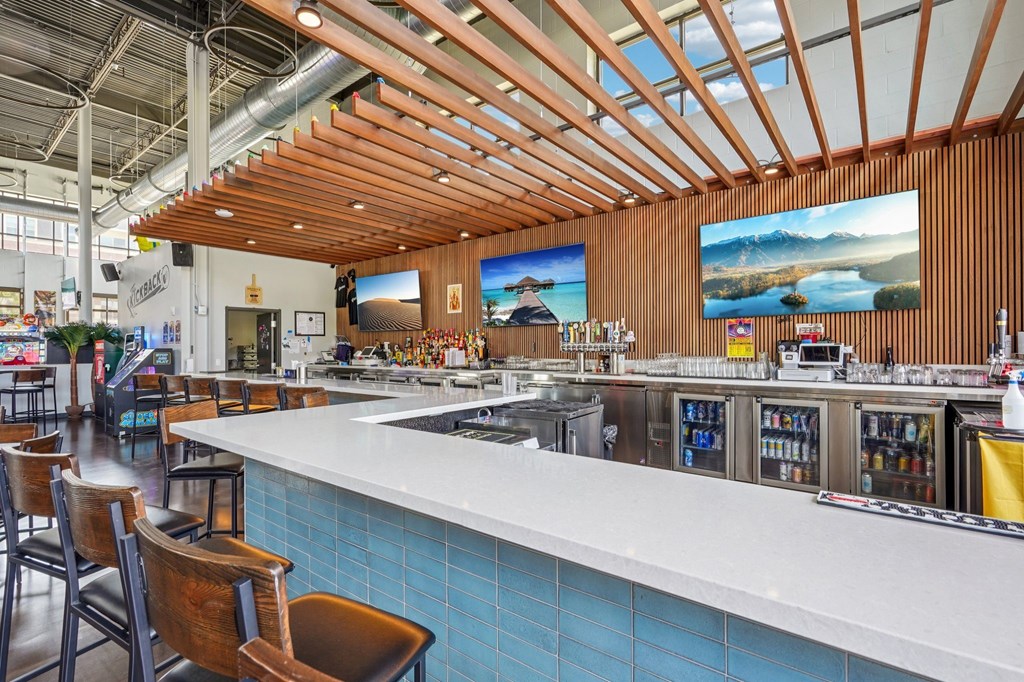 A bar with a white counter and blue tiles.