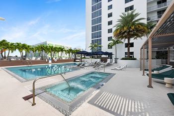 a swimming pool at a hotel with palm trees