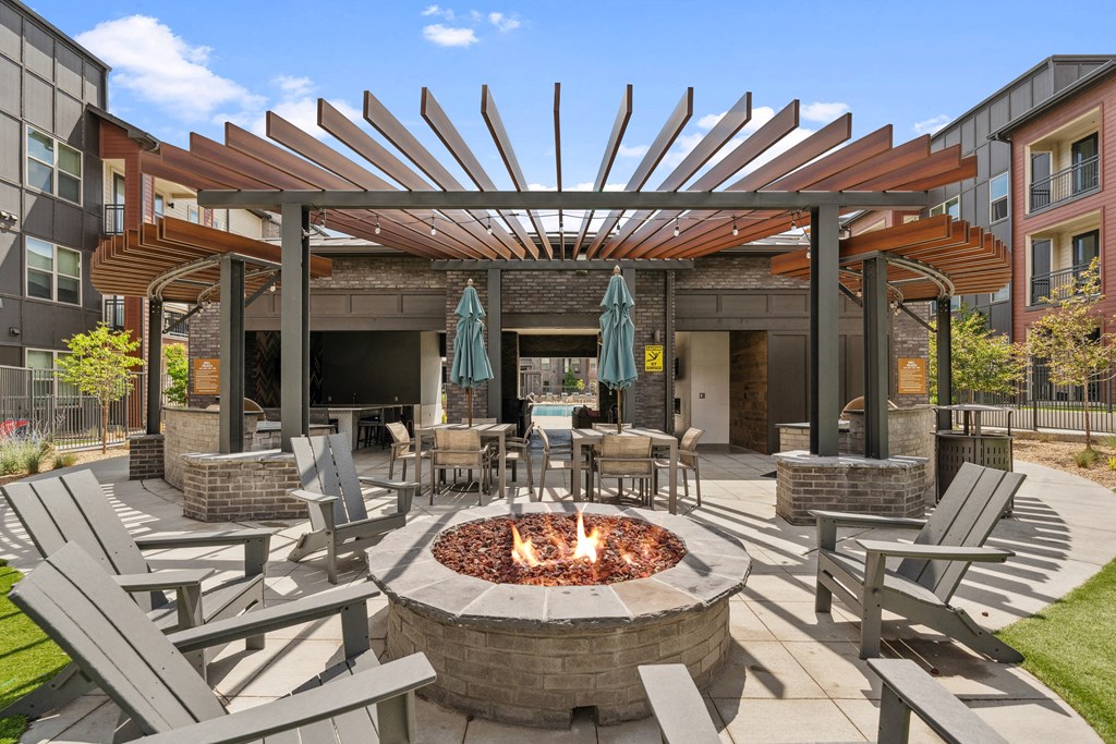 a patio with a fire pit and tables and chairs