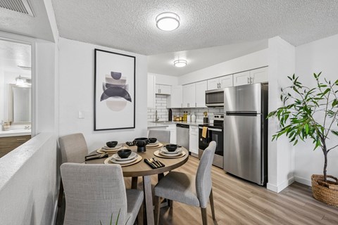 A modern kitchen with a dining table set for four.
