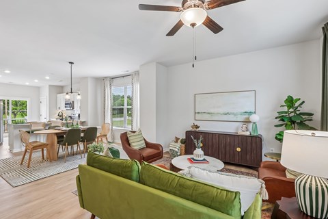 A living room with a green couch and a ceiling fan.