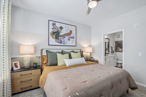 A bedroom with a large bed and a painting on the wall.