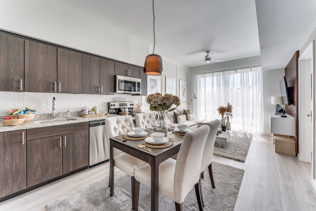 a dining room and kitchen with a table and chairs