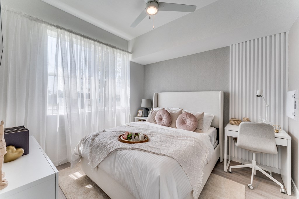 a bedroom with a white bed and a white desk