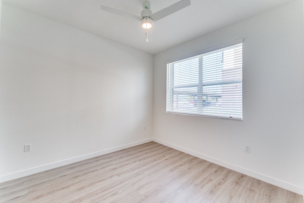 an empty room with white walls and a window