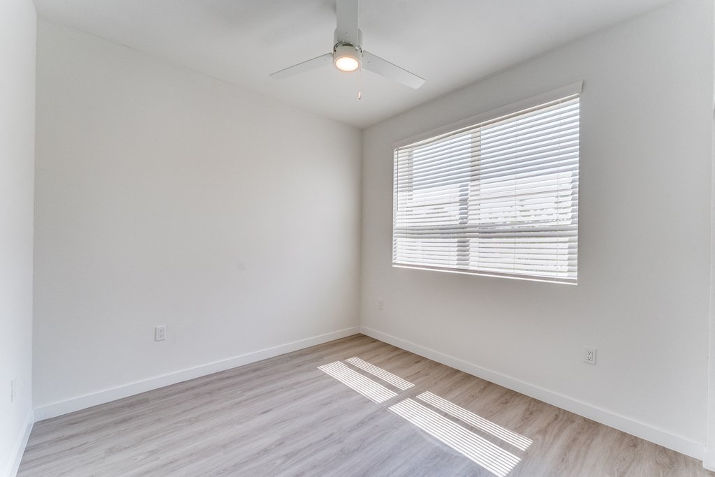 an empty room with white walls and a window
