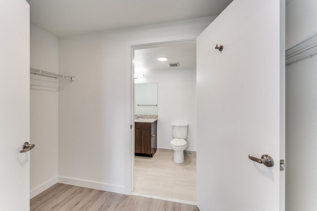 a door leading into a bathroom with a toilet and a sink
