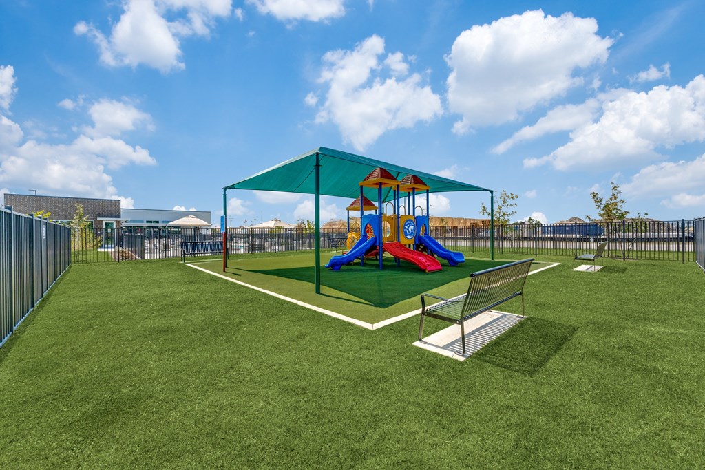 a playground with a swing set on top of a lush green field