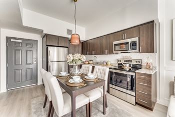 a kitchen and dining room with stainless steel appliances and a table