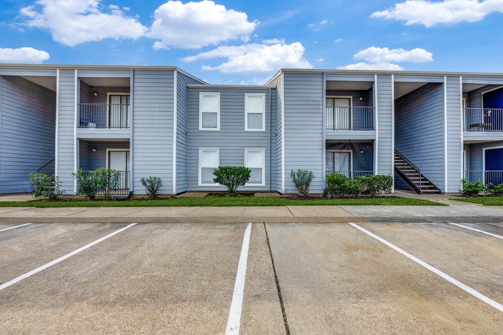 A row of grey apartment buildings with a clear blue sky above.
