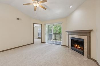 A living room with a fireplace and a ceiling fan.