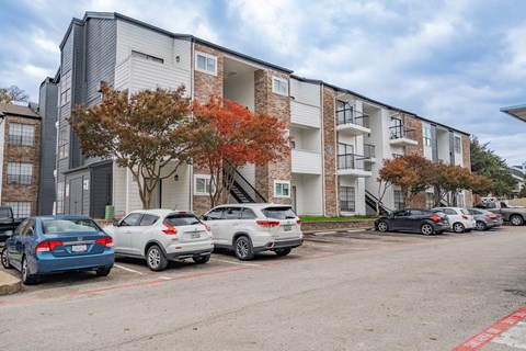 an apartment building with cars parked in front of it