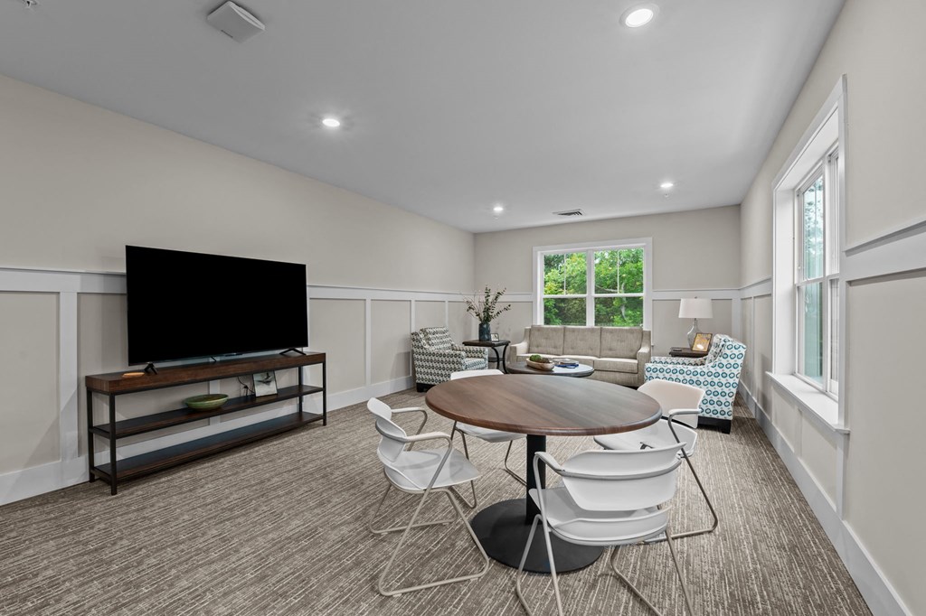 a living room with a table and chairs and a television