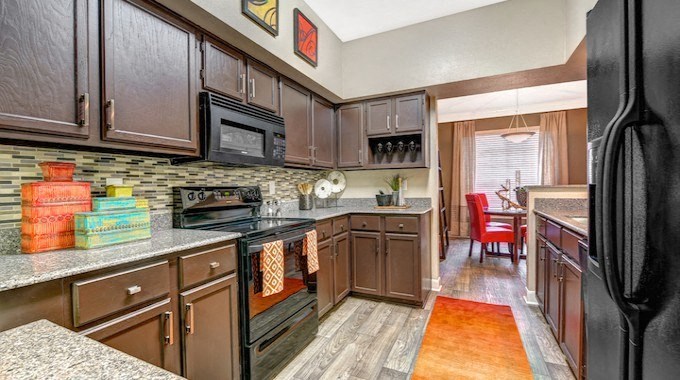 a kitchen with wooden cabinets and a stove and a sink