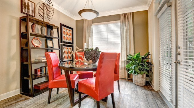 a dining room with orange chairs and a table