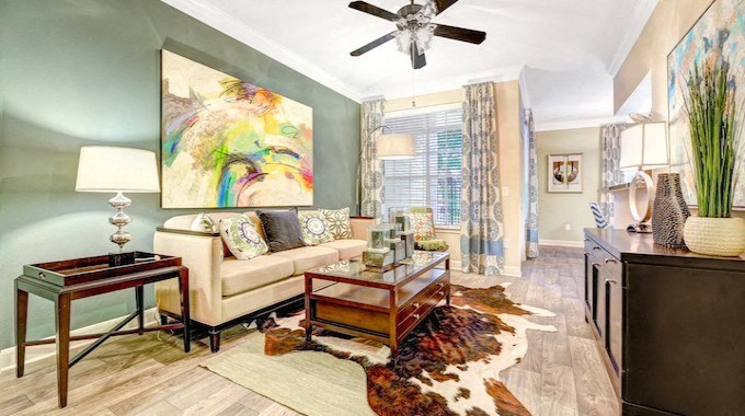 A living room with a couch, a coffee table, and a painting on the wall.