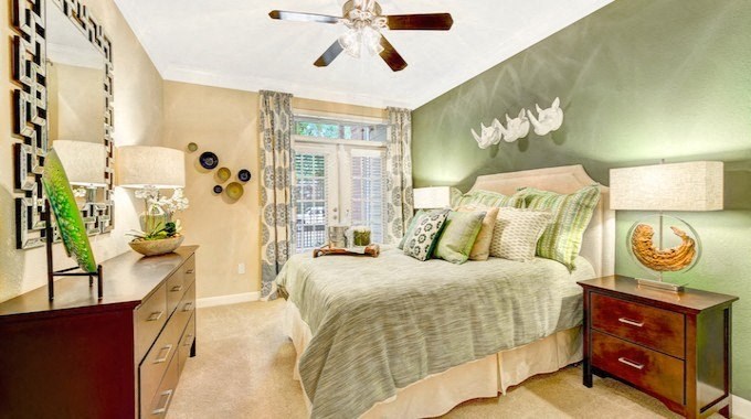 a bedroom with a bed and a ceiling fan