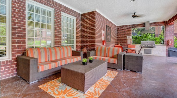 A patio with a striped couch and a table with a plant on it.