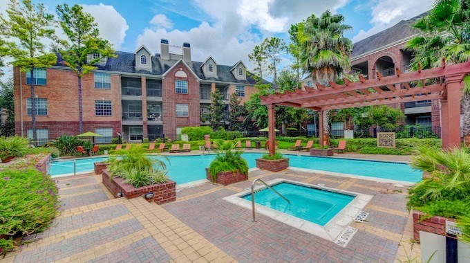 A large building with a pool in front of it.