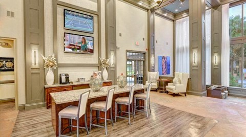 A dining room with a table set for four and a television mounted on the wall.