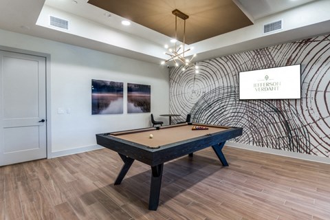 A pool table in a room with a wooden floor and a wall mural.