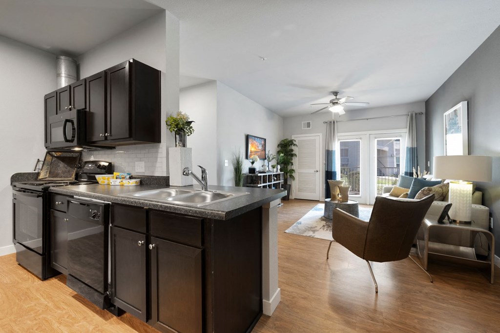 A modern kitchen with dark wood cabinets and a large island.