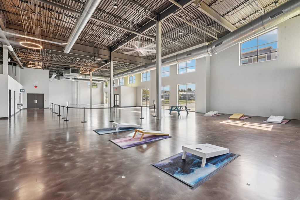 A spacious room with a high ceiling and large windows.
