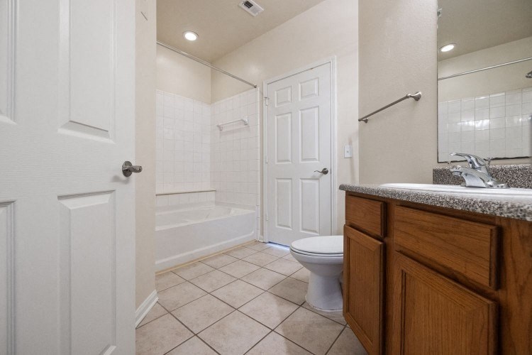 a bathroom with a toilet and a tub and a sink