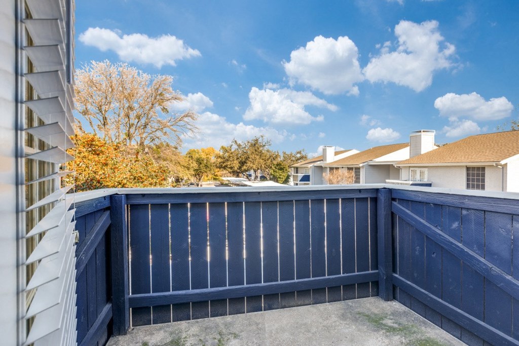 a blue fence with a house in the background