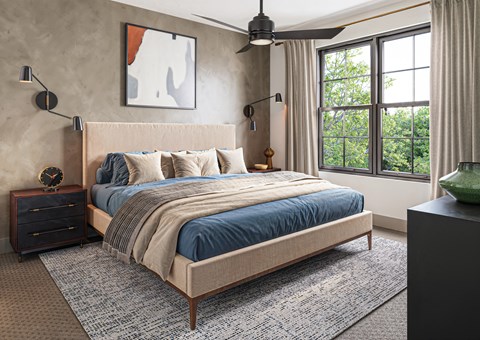 A bedroom with a large bed and a window overlooking trees.