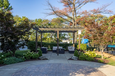 A gazebo is surrounded by trees and bushes in a park.