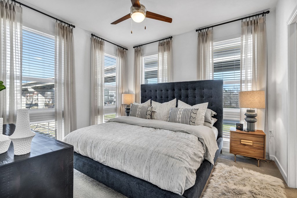 a bedroom with a large bed and a ceiling fan