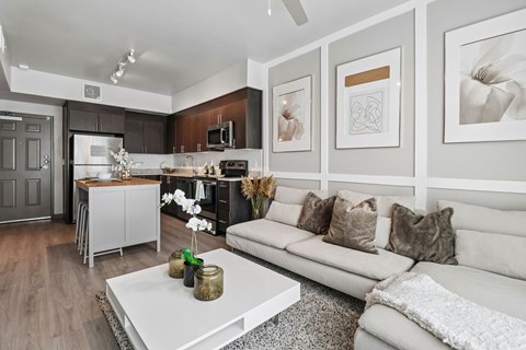 A modern living room with a grey sofa and a white coffee table.