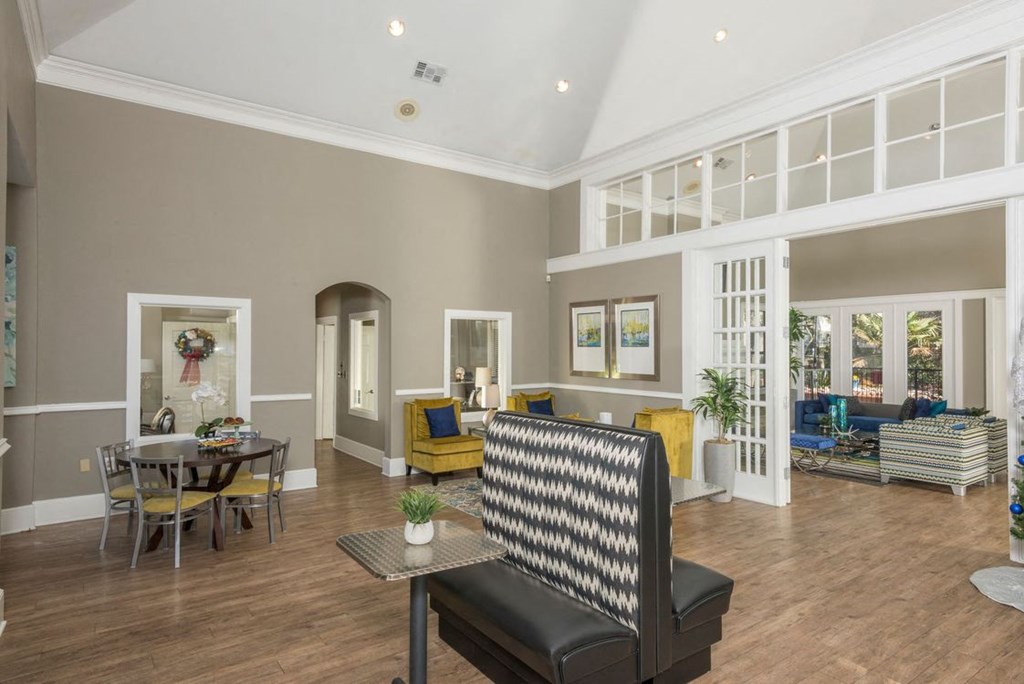 a living room with a couch and a chair in front of a table with a plant on