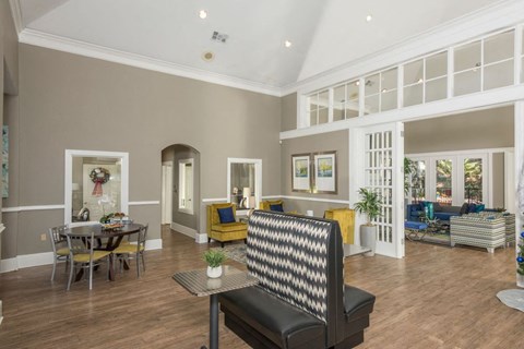 a living room with a couch and a chair in front of a table with a plant on