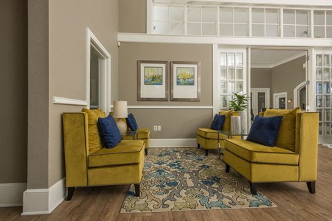 a living room with yellow couches and a blue rug