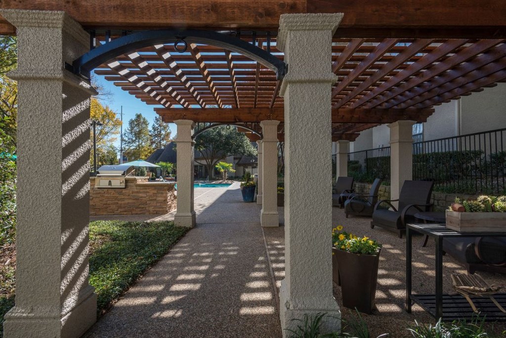 a pergola in a backyard with a pool