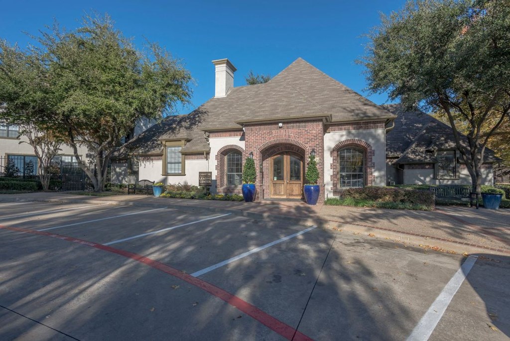 a house with a driveway and trees in front of it