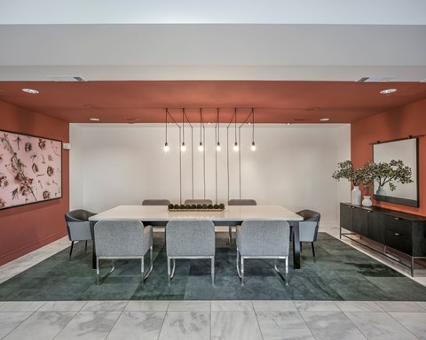 A modern dining room with a large table and chairs.