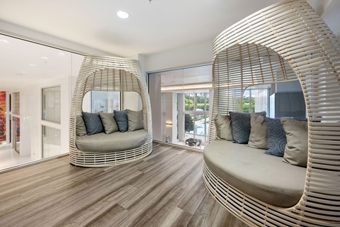 a living room with two chairs and a round mirror