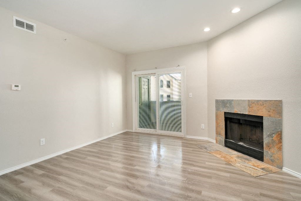 a living room with a fireplace and a door to a balcony