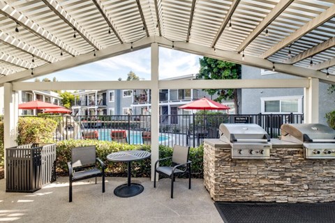 A patio with a grill and seating area.