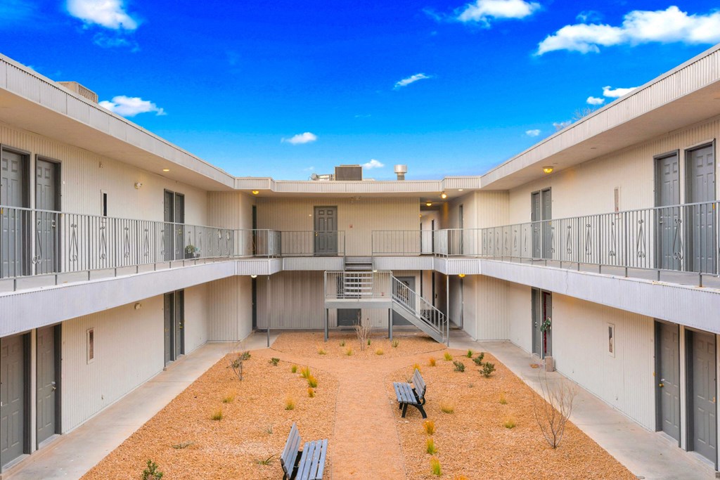 the courtyard of a building with a blue sky above it
