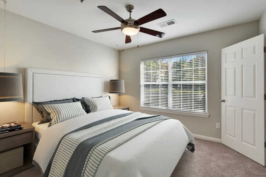 a bedroom with a bed and a ceiling fan