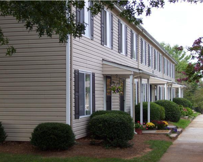 a white house with a sidewalk in front of it